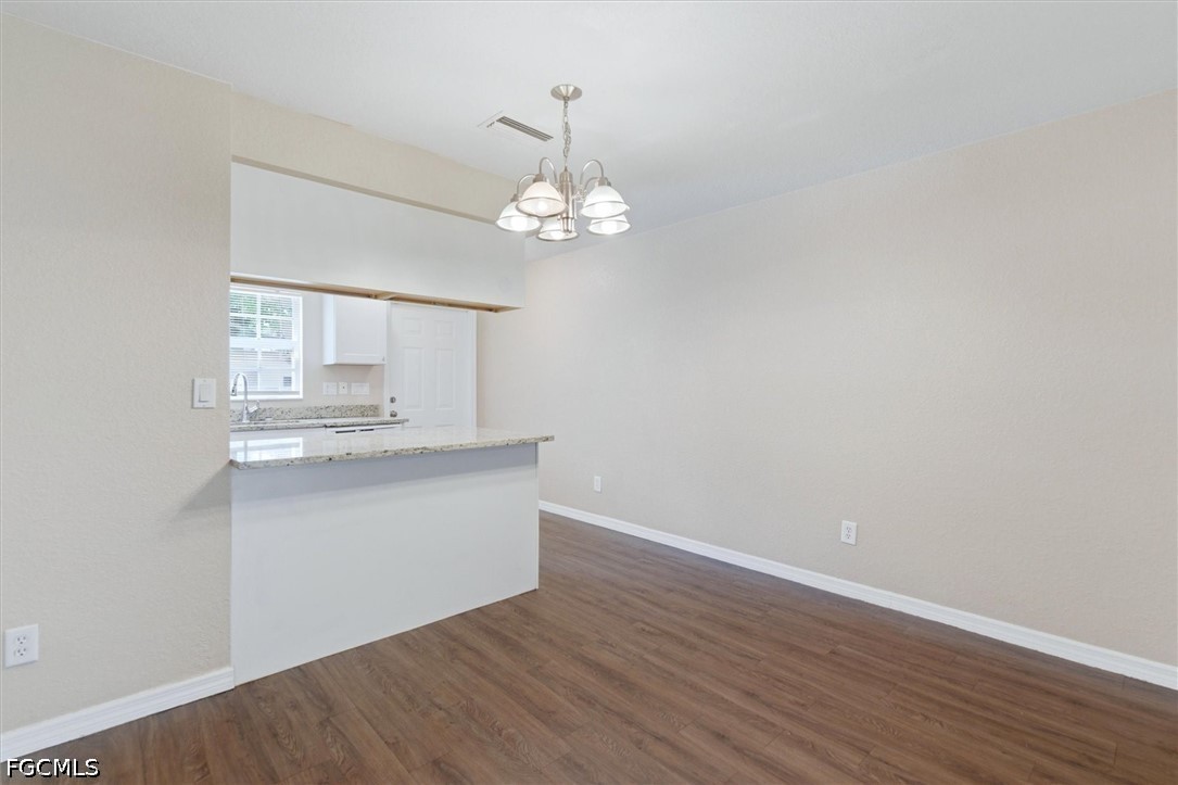 5257 Leeds Road Fort Myers, FL 33907 - Photo 8 of 30 a kitchen with a wooden floor and chandelier