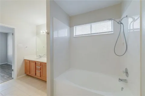 a bathroom with a tub sink and mirror