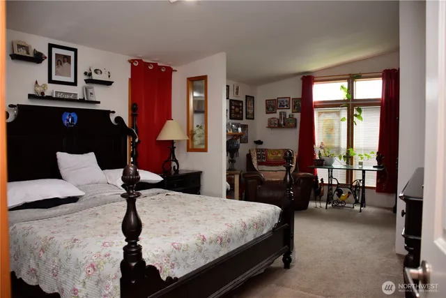 a bed sitting in a bedroom next to a window with pc on the dresser