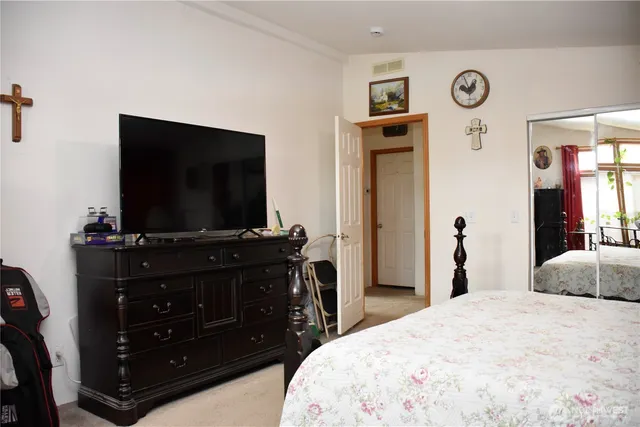 a bedroom with a bed and a flat screen tv