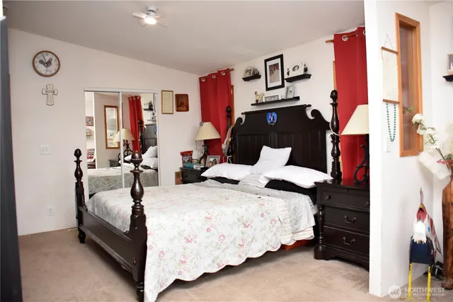 a bedroom with a bed lamp and dresser