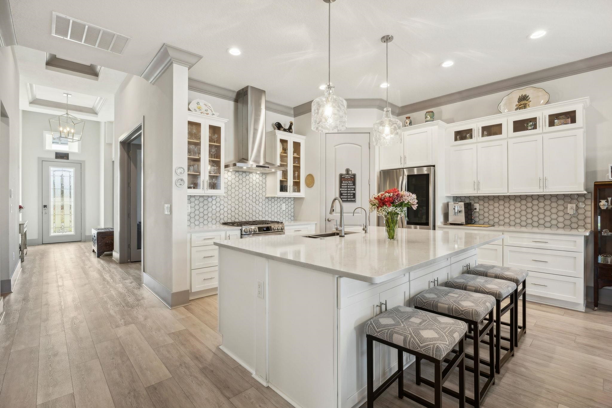 18 Rio Vista Drive Palm Coast, FL 32137 - Photo 12 of 73 a kitchen with stainless steel appliances kitchen island granite countertop a stove a sink a refrigerator and a dining table with wooden floor