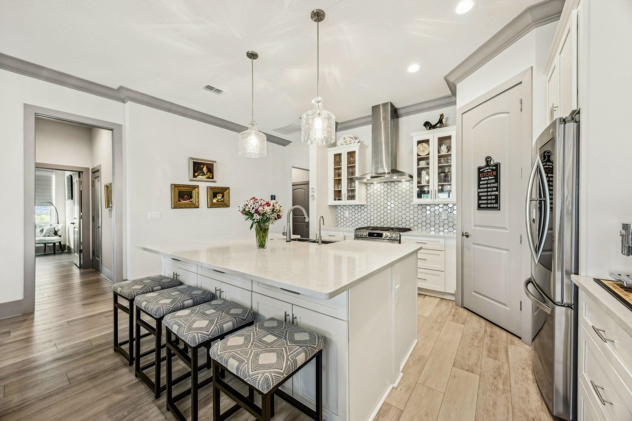 18 Rio Vista Drive Palm Coast, FL 32137 - Photo 15 of 73 Kitchen featuring crown molding, a kitchen bar, glass insert cabinets, a kitchen island with sink, and light wood-style floors