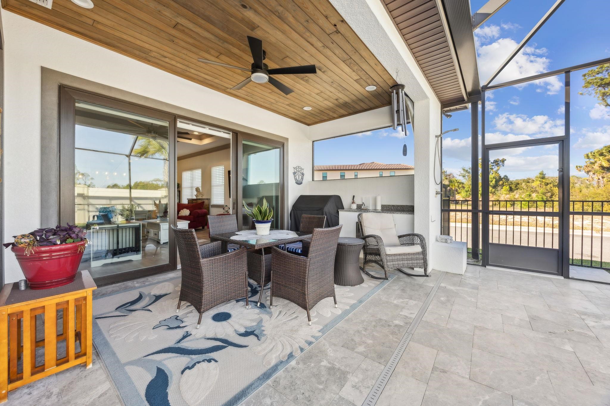 18 Rio Vista Drive Palm Coast, FL 32137 - Photo 28 of 73 View of patio / terrace with glass enclosure, a sunroom, outdoor dining space, a grill, and a ceiling fan
