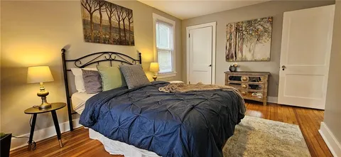 a view of a bedroom with furniture and wooden floor