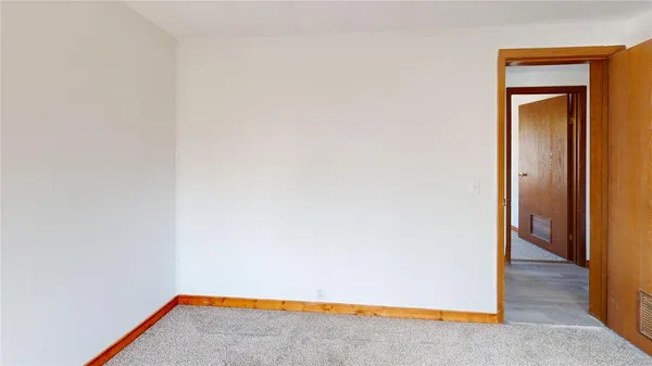a view of an empty room and wooden floor