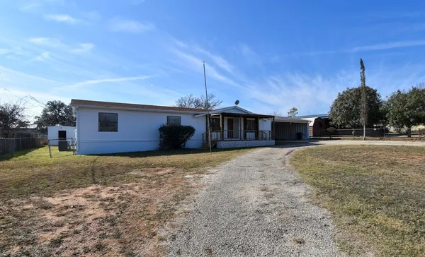 a view of a house with backyard and trees