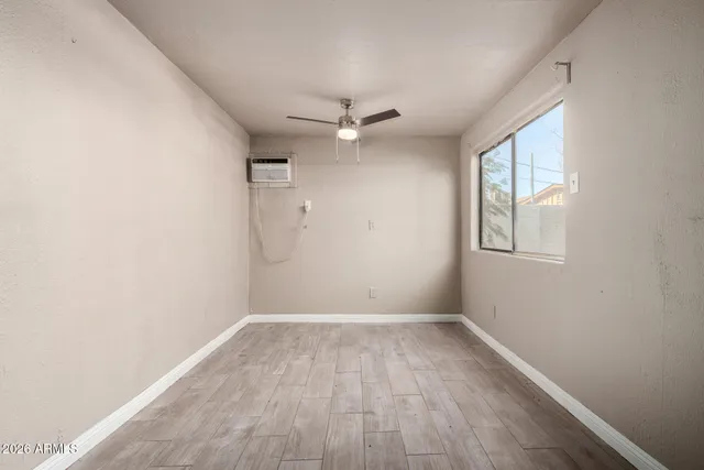 an empty room with a window and a ceiling fan