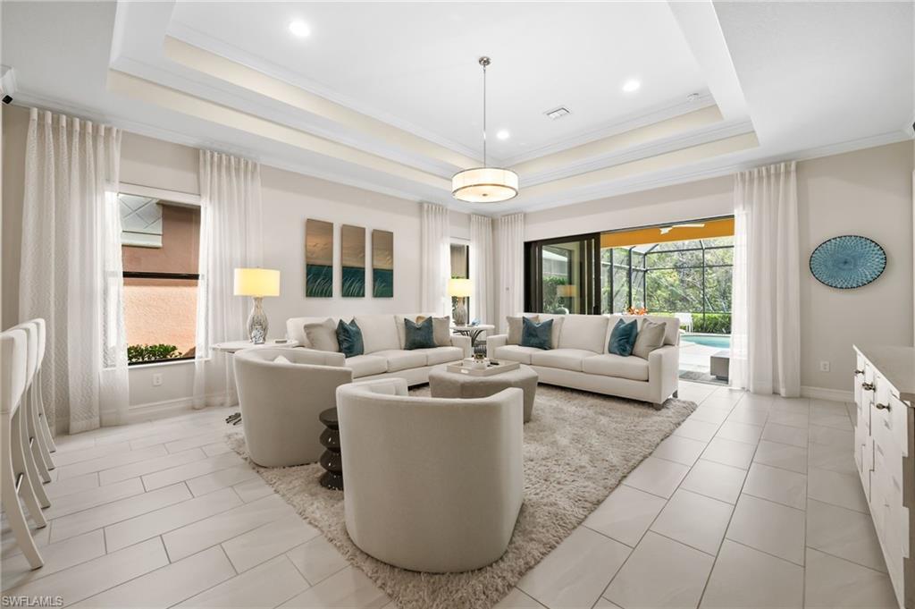6608 Roma Way Naples, FL 34113 - Photo 13 of 50 Living room with a tray ceiling, crown molding, and light tile patterned flooring