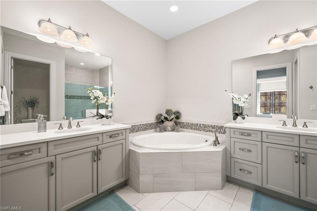6608 Roma Way Naples, FL 34113 - Photo 16 of 50 Bathroom with plus walk in shower, tile patterned flooring, and vanity