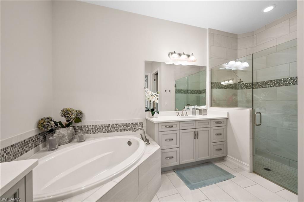 6608 Roma Way Naples, FL 34113 - Photo 17 of 50 Bathroom featuring tile patterned floors, separate shower and tub, and vanity