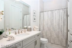 6608 Roma Way Naples, FL 34113 - Photo 23 of 50 Bathroom featuring toilet, a shower with shower curtain, and vanity