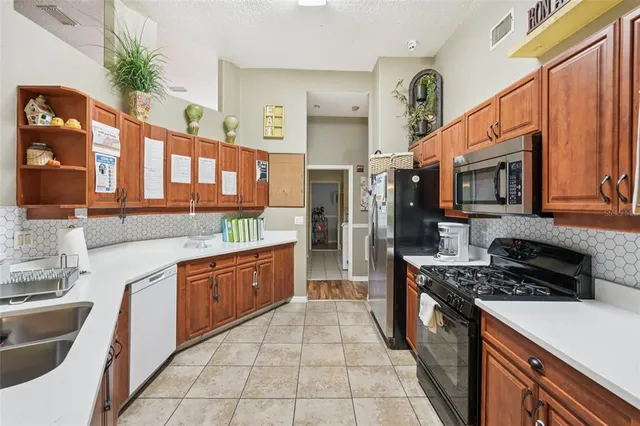 a kitchen with stainless steel appliances granite countertop a stove a sink and a refrigerator