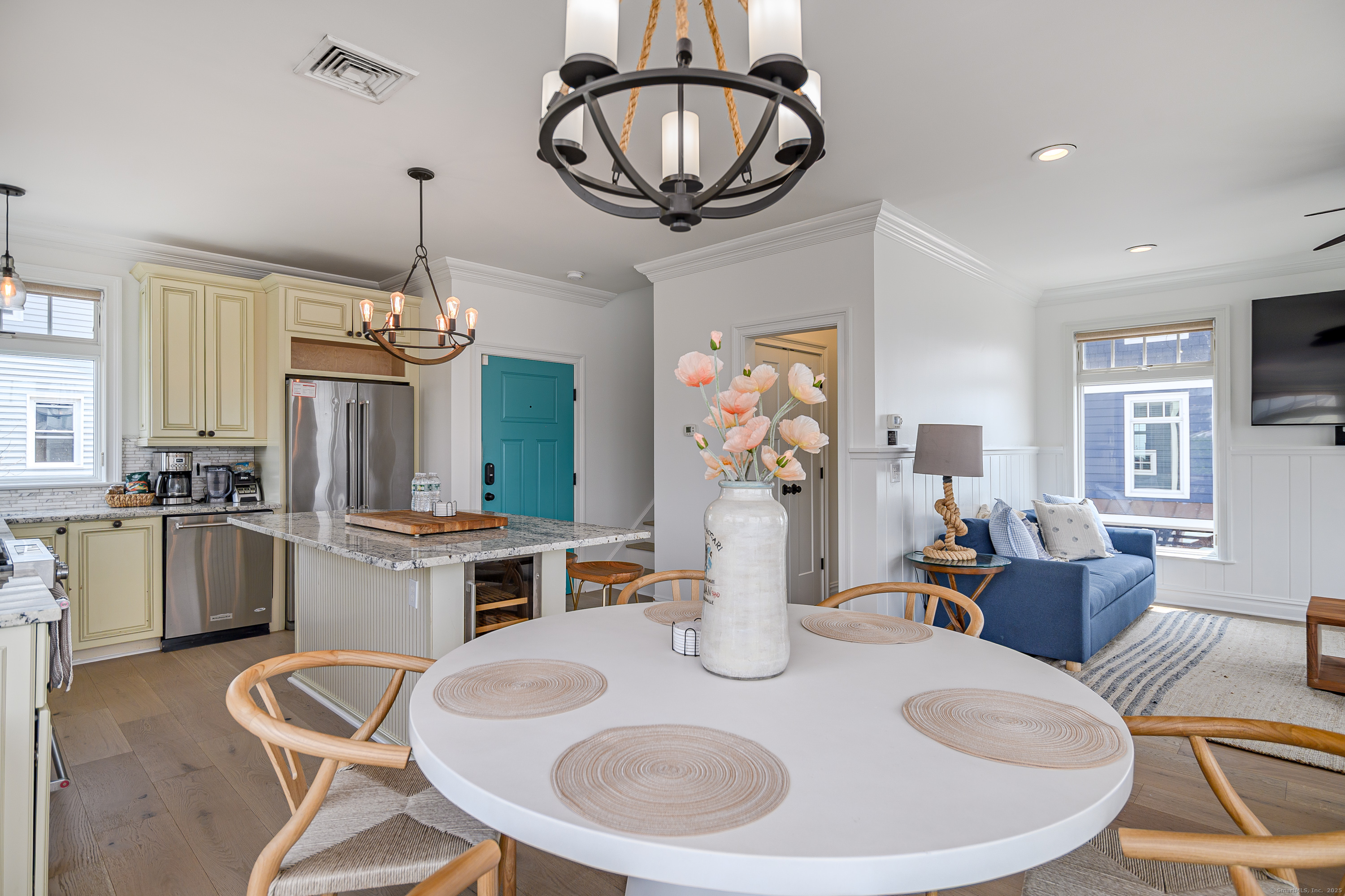 2154 Fairfield Beach Road Fairfield, CT 06824 - Photo 11 of 39 a dining room with wooden floor a chandelier a wooden table and chairs
