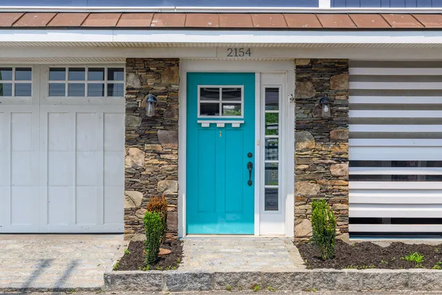 a front view of a house with a garden