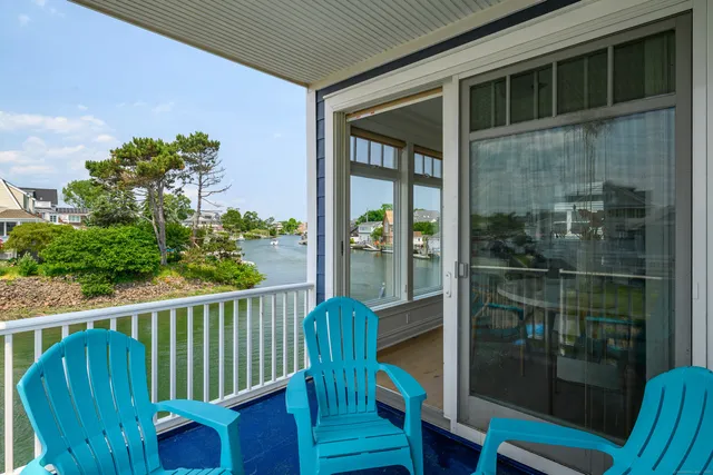 a view of a porch with a floor to ceiling window and wooden fence
