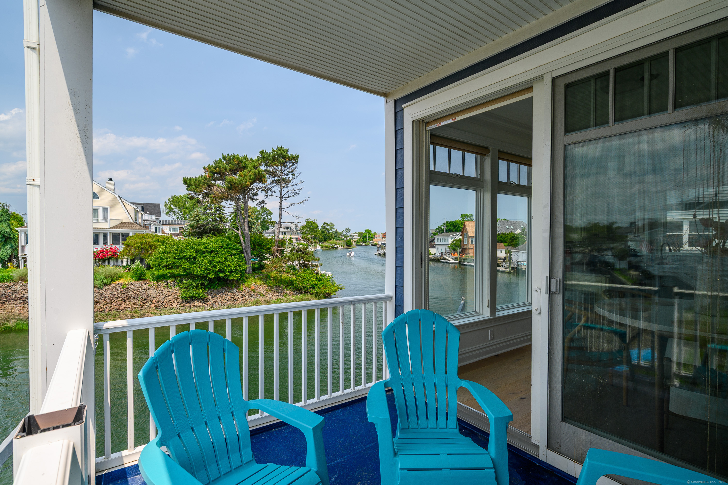 2154 Fairfield Beach Road Fairfield, CT 06824 - Photo 32 of 39 a view of a porch with a floor to ceiling window and wooden fence