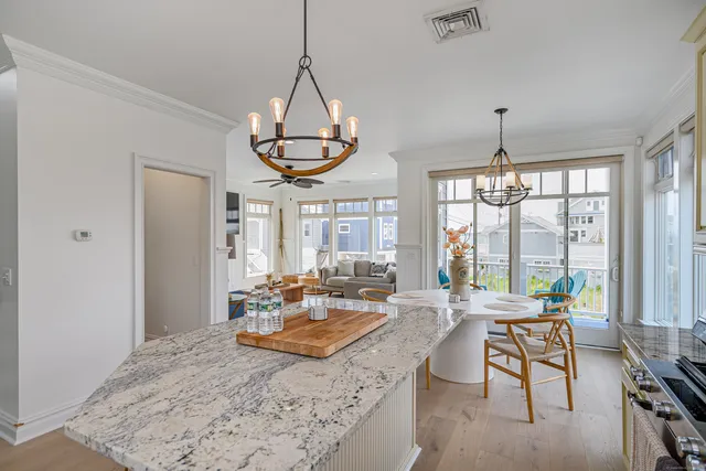 a living room with couch a dining table and a chandelier