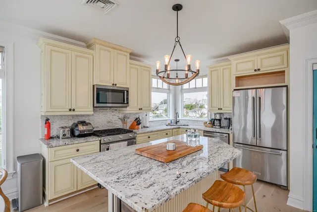 a kitchen with stainless steel appliances granite countertop a sink refrigerator stove and microwave