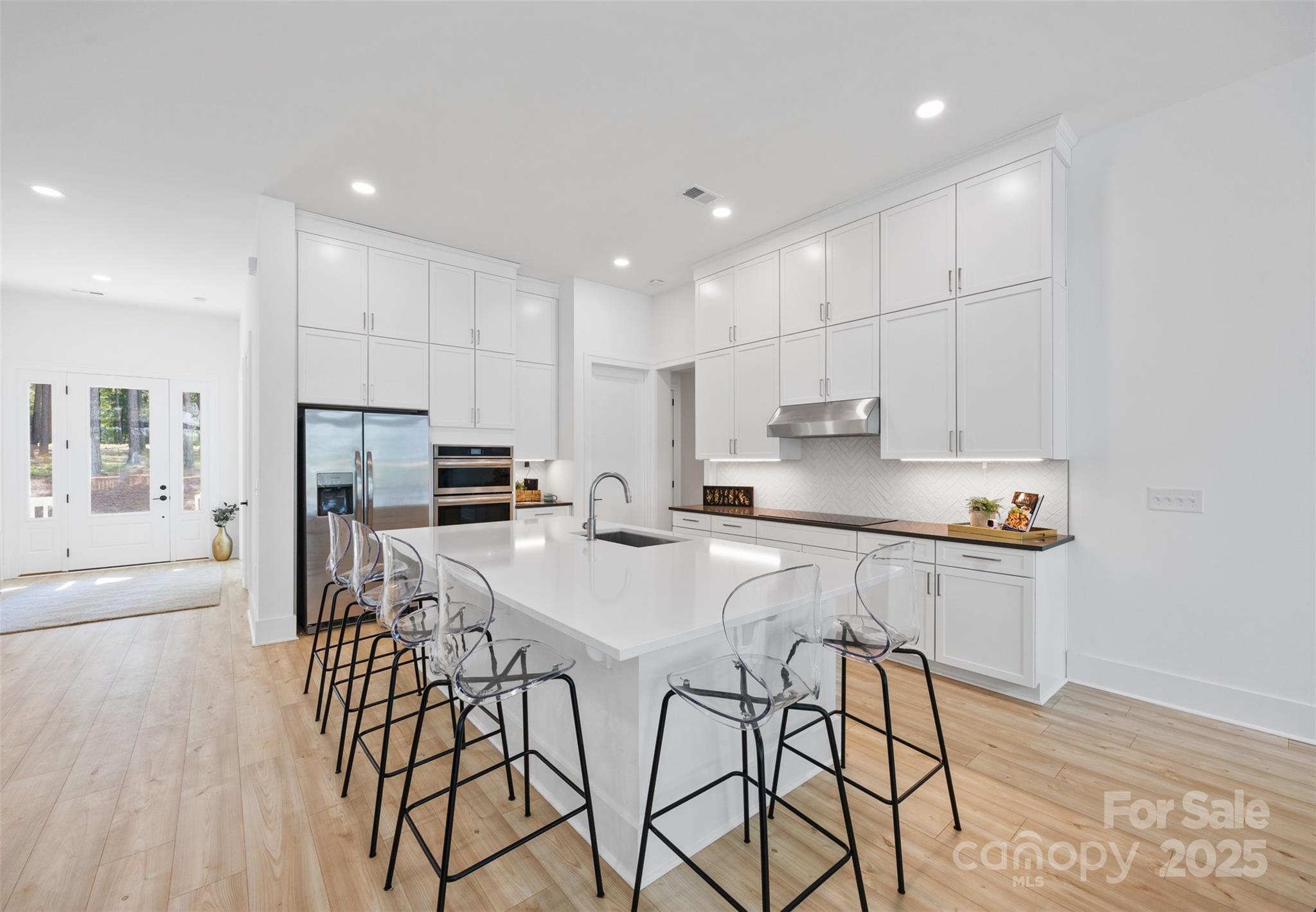 1075 Retreat Way Ridgeway, SC 29130 - Photo 11 of 48 a kitchen with stainless steel appliances granite countertop a stove a sink a refrigerator and white cabinets with wooden floor