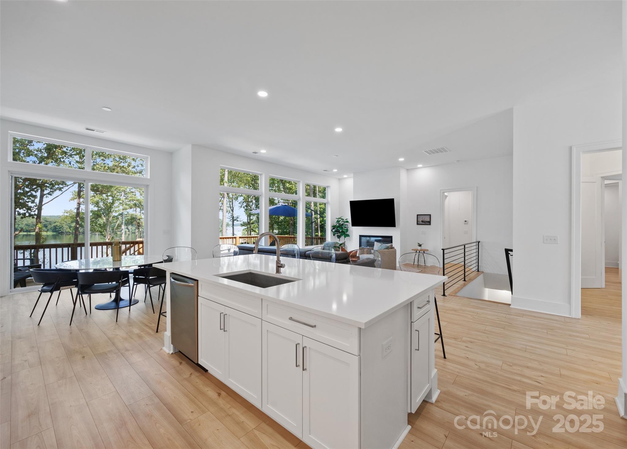 1075 Retreat Way Ridgeway, SC 29130 - Photo 12 of 48 a large white kitchen with wooden floor a sink a dining table and chairs