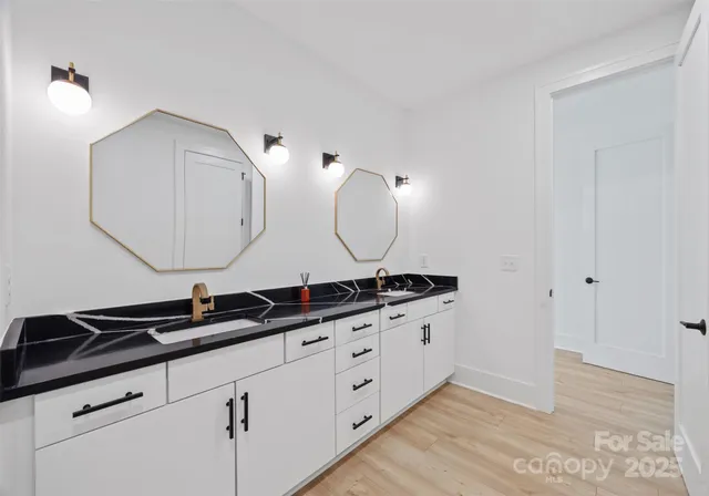 a bathroom with double vanity sinks and a mirror