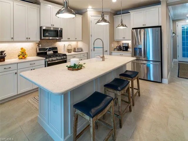 a kitchen with a sink a kitchen island and stainless steel appliances