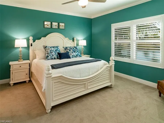 a bed sitting in a room next to a lamp