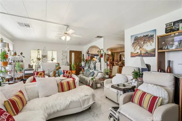 a living room with furniture kitchen view and a chandelier