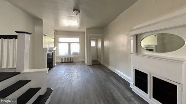 a view of a livingroom with wooden floor and a fireplace