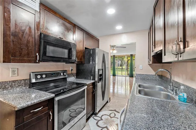 a kitchen with granite countertop stainless steel appliances and a sink