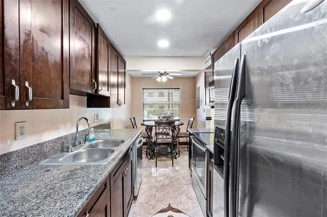 a kitchen with stainless steel appliances granite countertop a sink stove and refrigerator