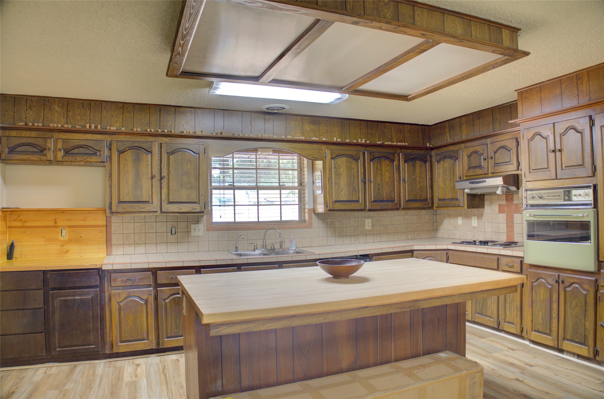 12420 South Garnett Road Broken Arrow, OK 74011 - Photo 7 of 44 Kitchen featuring wood-finish cabinetry, tile countertops, a built-in oven, and a center island with a wood-finish surface