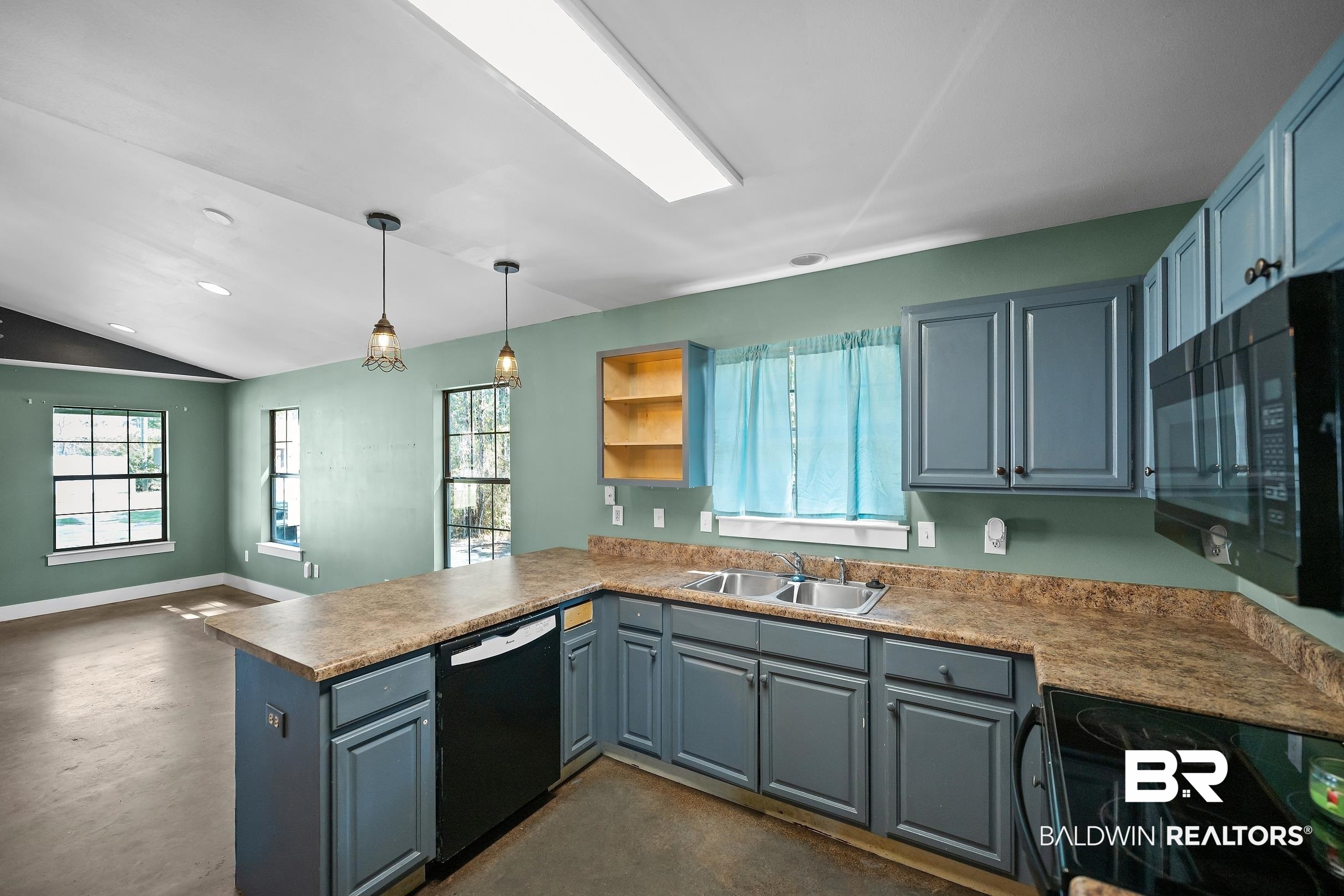 2000 Maria Lane Lillian, AL 36549 - Photo 6 of 35 Kitchen featuring finished concrete flooring, black appliances, a peninsula, healthy amount of natural light, and vaulted ceiling