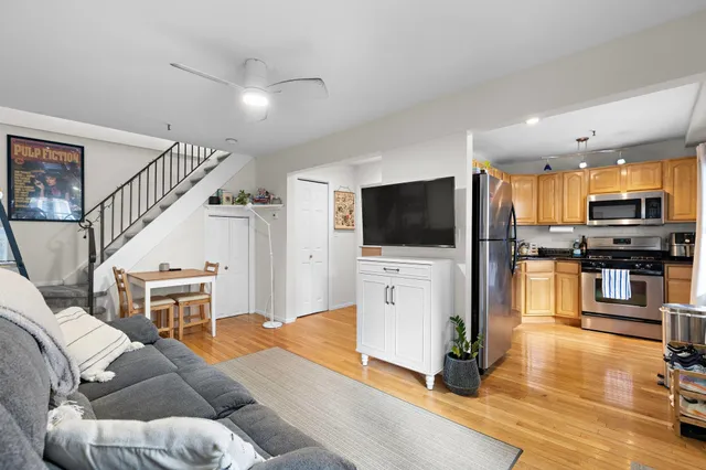 a living room with furniture kitchen view and a flat screen tv