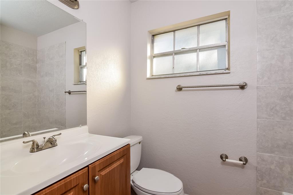 3610 West Leila Avenue Tampa, FL 33611 - Photo 13 of 15 a bathroom with a sink vanity mirror and toilet