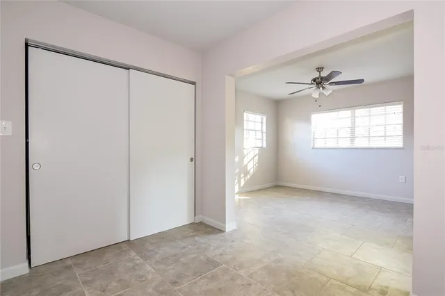 an empty room with windows and closet