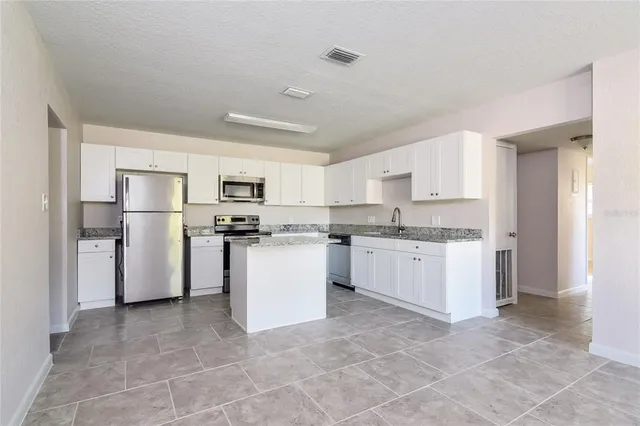 a kitchen with refrigerator and cabinets