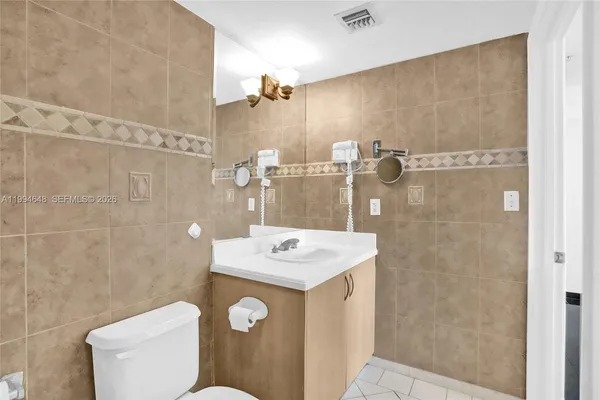 a view of a hallway with closet and a bathroom