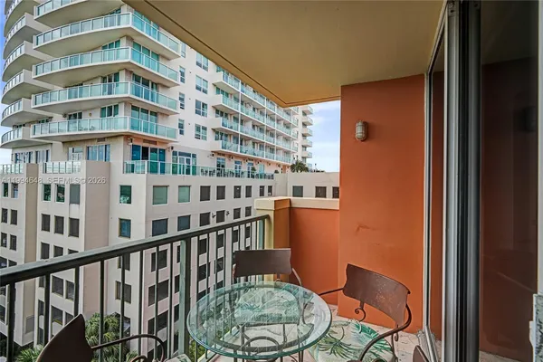 a view of a balcony with two chairs and a potted plant
