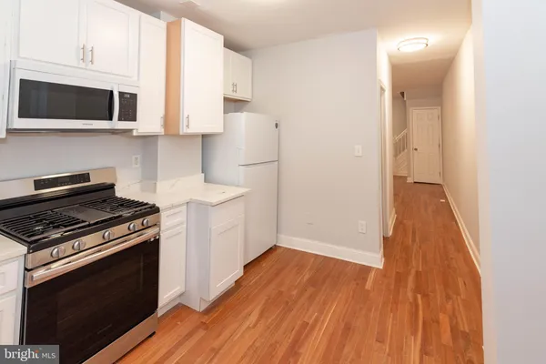 a kitchen with wooden floors and appliances