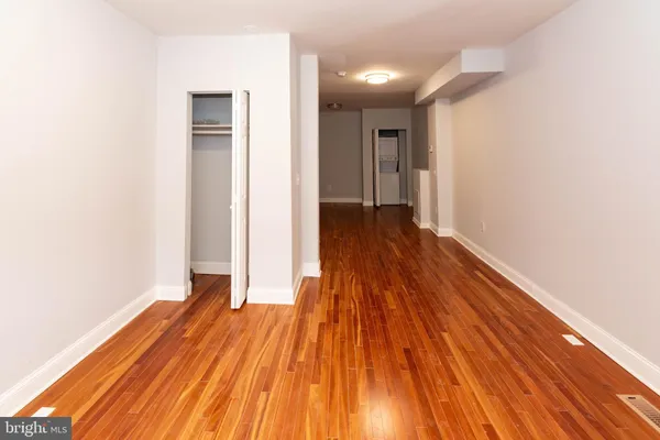 a view of a room with wooden floor and a ceiling fan