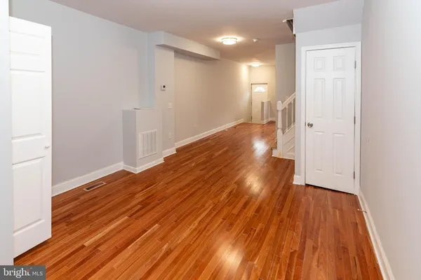 a view of a room with wooden floor and a hallway