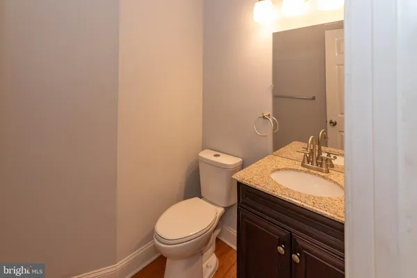 a bathroom with a granite countertop toilet and sink