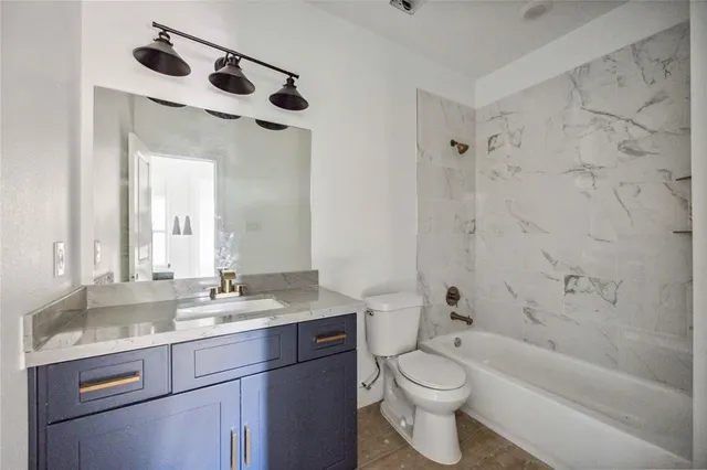 a bathroom with a granite countertop sink a toilet and a mirror