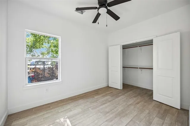 a view of empty room with wooden floor and window