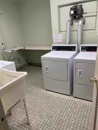 a living room with furniture and a dining table with a sink