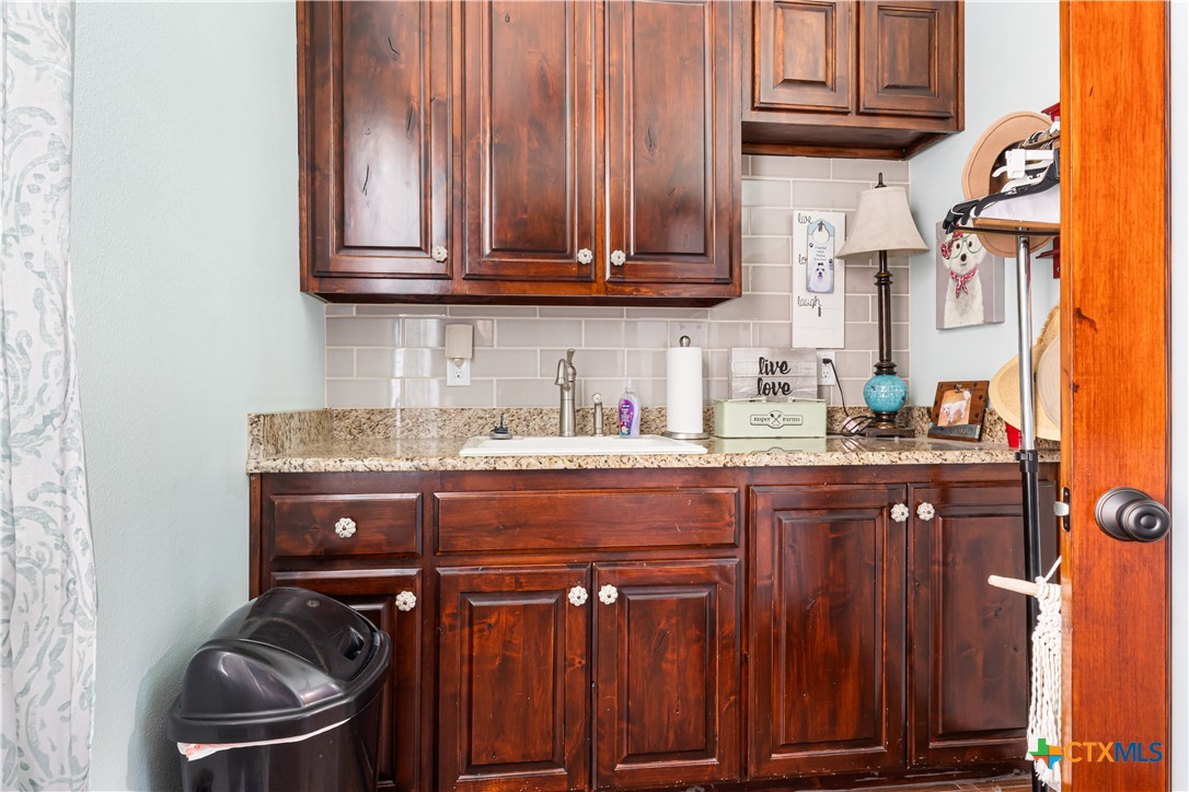 790 Spanish Grant Road Goliad, TX 77963 - Photo 29 of 41 a kitchen with wooden cabinets and a stove top oven