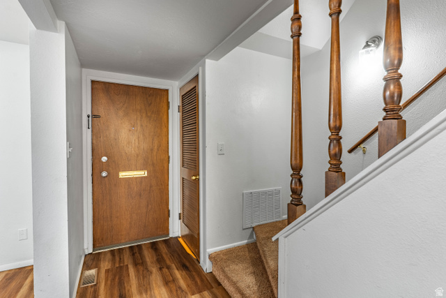728 400 East Orem, UT 84097 - Photo 7 of 30 Entryway featuring wood-finish flooring, a solid wood entry door with brass mail slot, and an adjacent louvered door