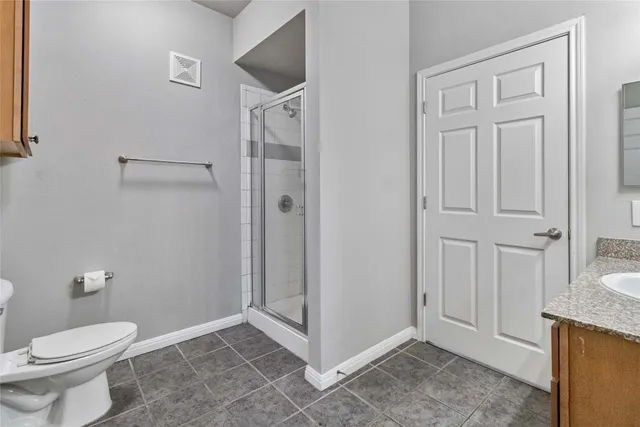a bathroom with a granite countertop sink mirror and toilet